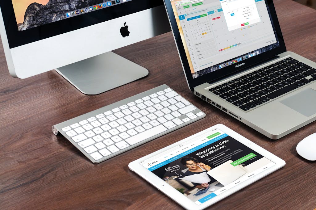 A sleek office desk setup featuring Apple devices: iMac, MacBook, and iPad. Ankara web tasarım ajansı